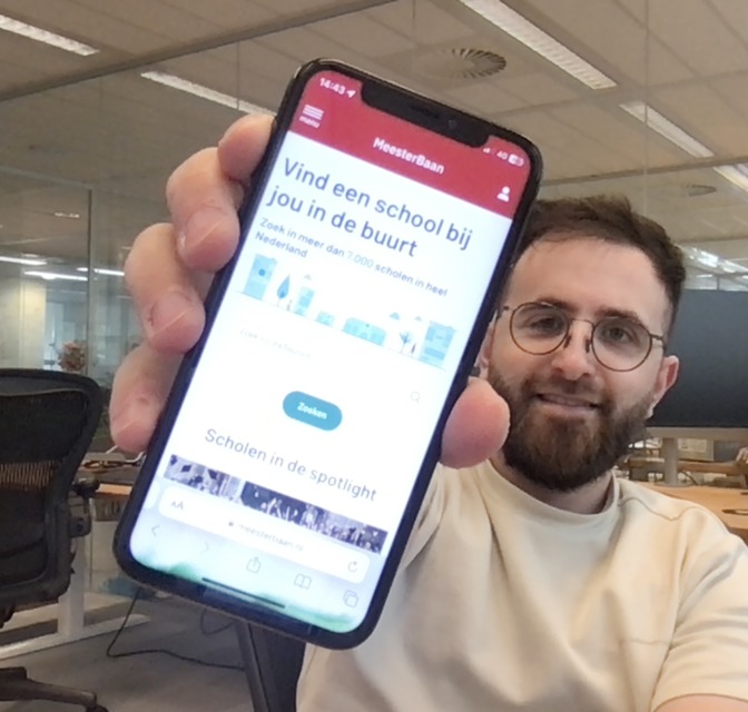 Hakan Topac (designer) laat de Meesterbaan website zien op zijn telefoon