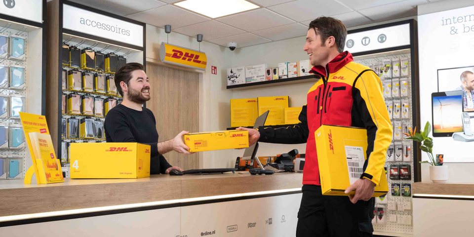 DHL foto: Man neemt een pakket aan van de DHL bezorger